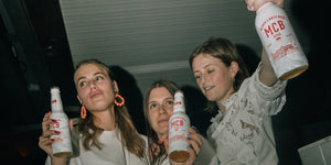 Trois filles tenant des bouteilles de bières Monte Carlo Beer en soirée à Monaco.