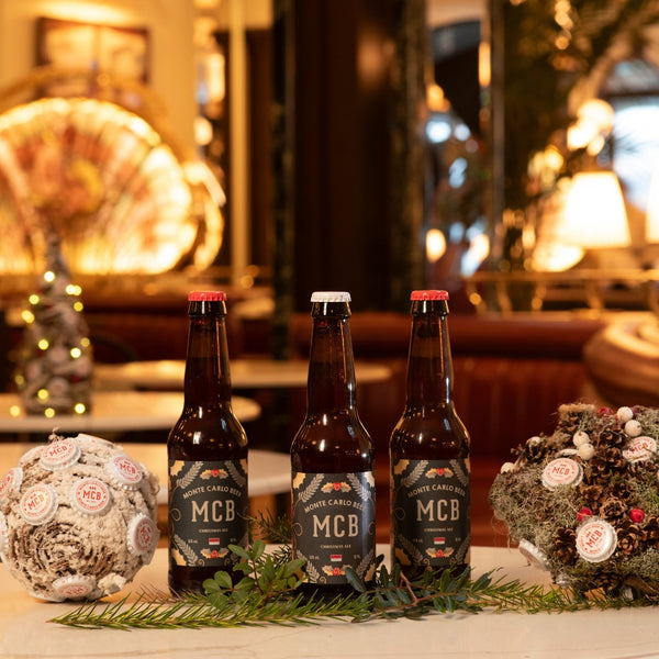 Trois bouteilles de bières Monte Carlo Beer édtion noël posées sur une table à l'Hôtel de Paris.
