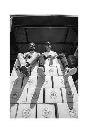William et Anthony assis sur des cartons MCB