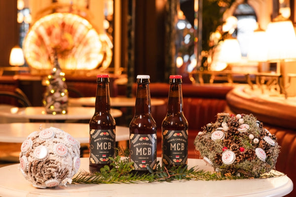 Trois bouteilles de bières artisanales de Monte Carlo Beer spécial Noël posée sur une table du restaurant de l'hôtel de Paris