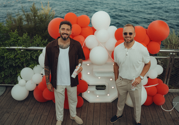 Anthony et William, entourée de ballons rouge et blanc et un chiffre 5, avec en fond la mer de Monaco