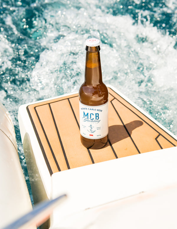La bouteille de blonde MCB édition "Yatching Club" posé sur un bateau